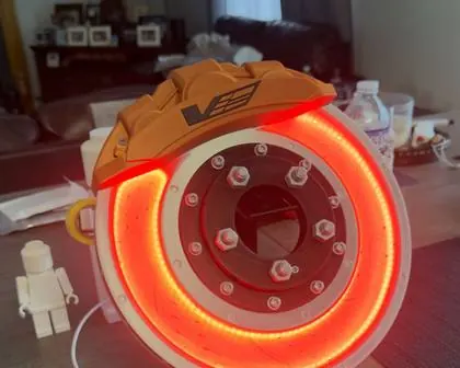 The 3D printed LED rotor and caliper glowing red on a table