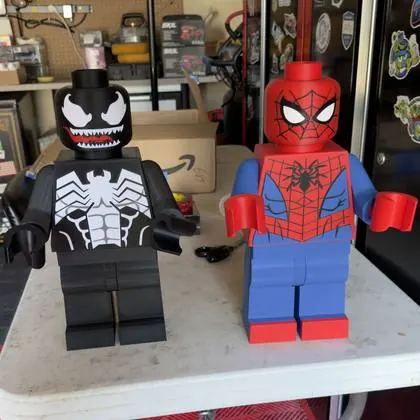 The 3D printed Venom and Spider-Man figures photographed on a table